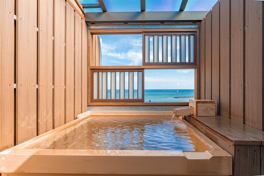 客室の温泉掛流し露天⾵呂の一例。海風と潮の香りに包まれて、のんびりと湯浴みを。