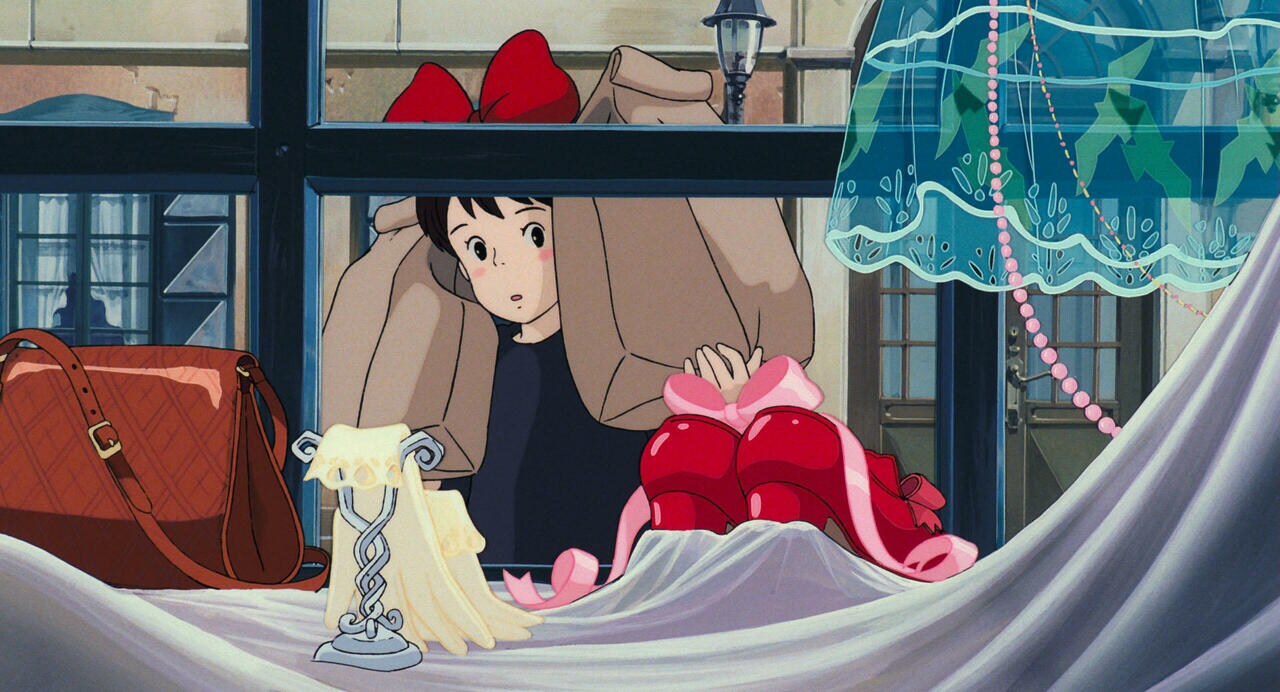 キキはディスプレイされた赤い靴に見惚れ「ステキ」と口にする　© 1989 Eiko Kadono/Hayao Miyazaki/Studio Ghibli, N
