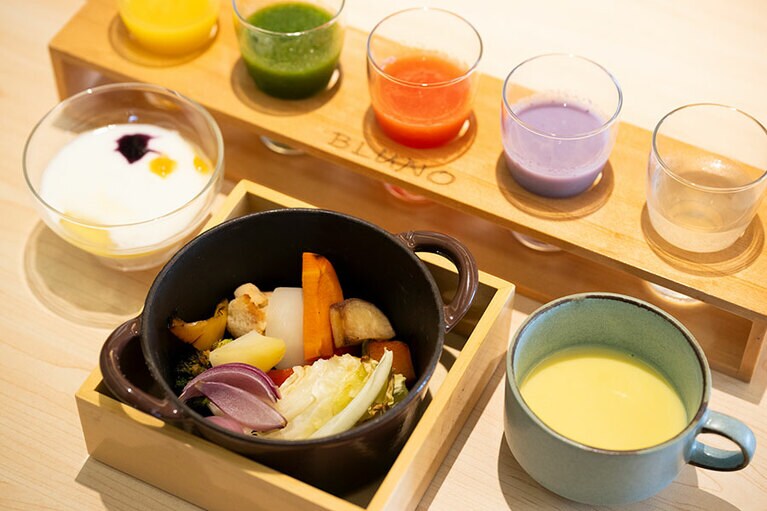 朝食は小鍋に地の野菜を蒸し焼きにしたもの、5種のジュースは旬のフルーツや野菜を使ってヘルシーに。