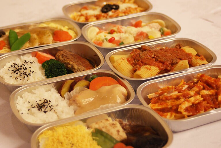 エコノミークラスのメインディッシュの一例。ビールやワイン、テキーラなどのアルコール類のサービスもある。