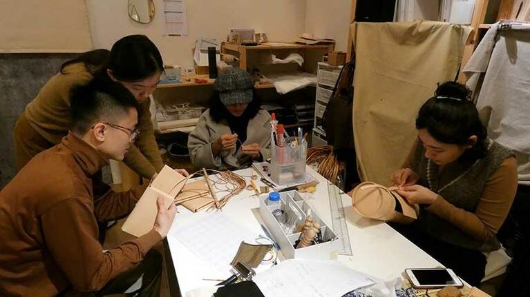 創業者の張雲帆さん、劉立祥さんとアミ族のスタッフ。6月に販売開始となる新商品のサンプルを製作中。