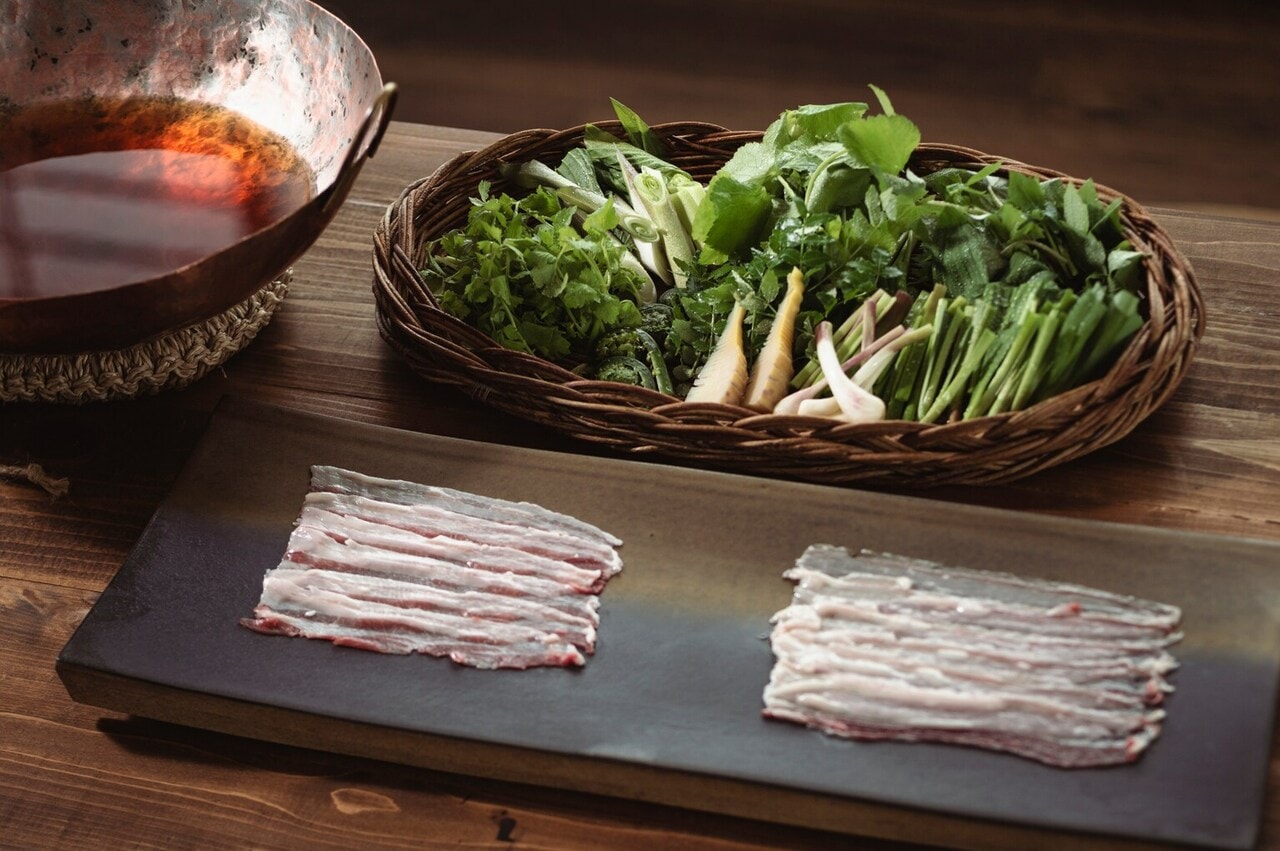 「山菜鍋」。左にあるのは、一枚の銅板を金鎚で叩き起こして器にする、鎚起銅器という燕三条の伝統的な技術で作られた鍋。なんと井上シェフの手作り。Restaurant UOZENでは使用する食器類も地産にこだわっている。