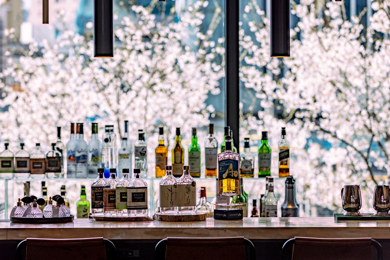 柔らかな灯りに照らされた桜がバーカウンターの窓一面に広がり、春の夜にふさわしい落ち着いた雰囲気を演出する。ライトアップは、2026年3月27日（金）～4月10日（金）の約2週間限定で実施予定。（※桜の開花によって変更の可能性あり）