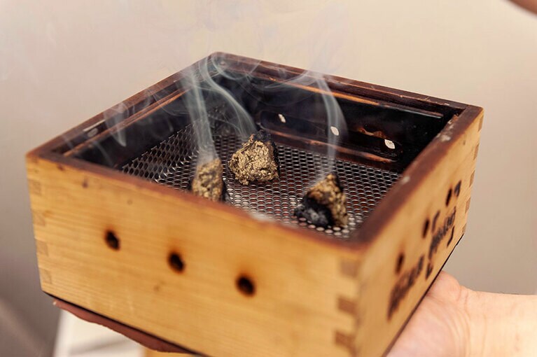 箱の中にもぐさを置いて火をつけ、蓋をしてお腹などの患部にのせて使う「箱灸」。