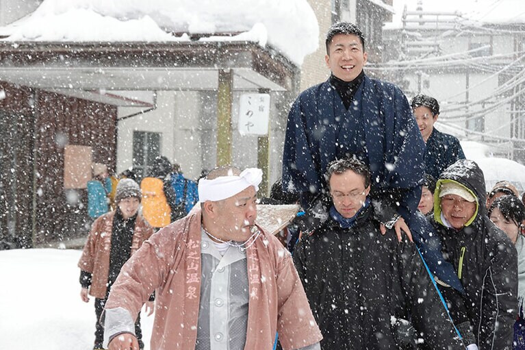 雪が舞う中、仲間たちに担がれて「地炉」に向かう。