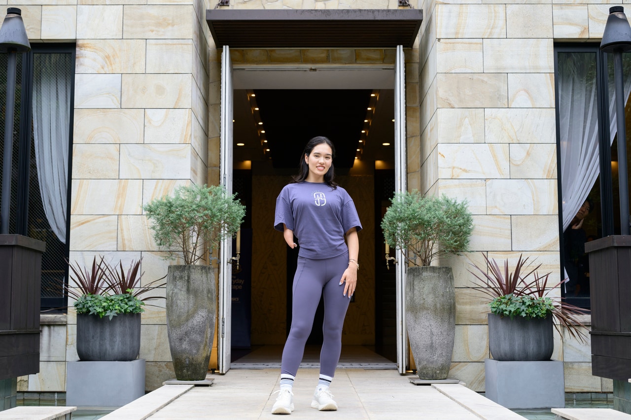 会場の前で微笑む一ノ瀬メイさん。明るく前向きなエネルギーが印象的。