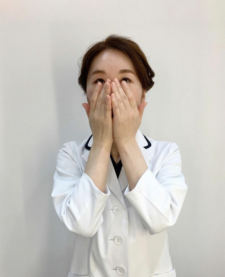 両手で顔を包み込むようにして、真ん中から外側のフェイスラインまで優しく手のひら全体を使って滑らせる。