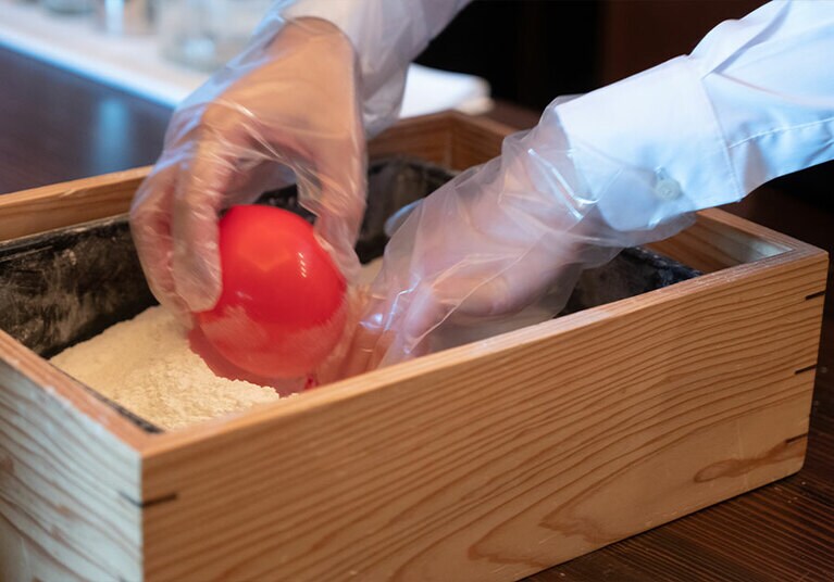 空気が入った風船を小麦粉の中に沈めて穴を空けると……。