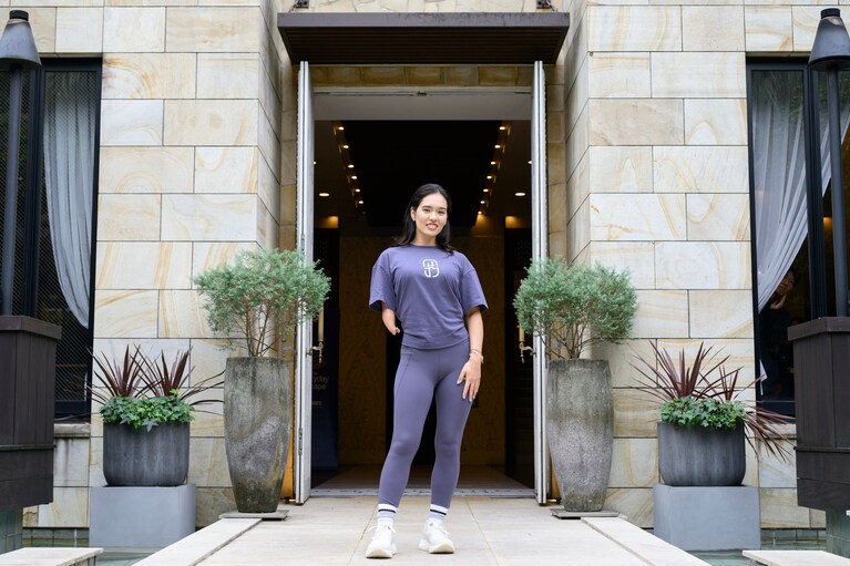 会場の前で微笑む一ノ瀬メイさん。明るく前向きなエネルギーが印象的。