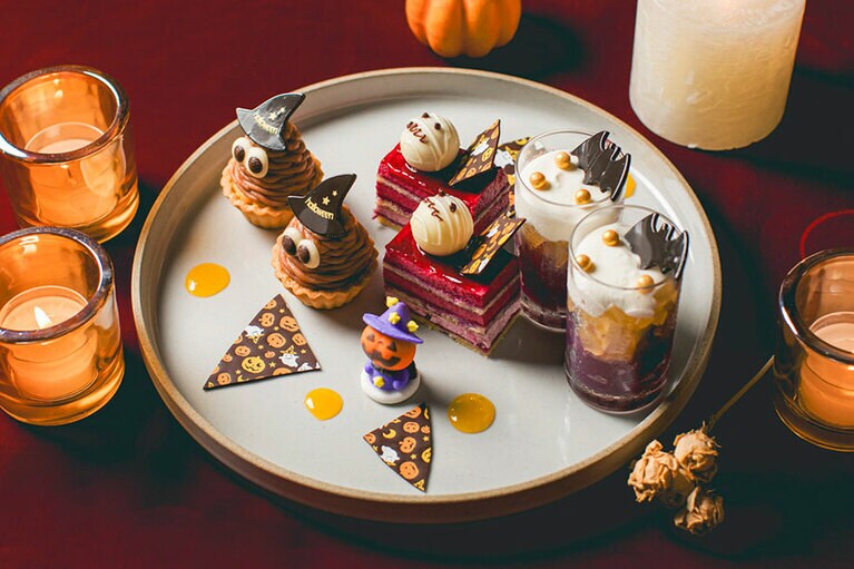 カシスオペラ、モンブランタルト、リンゴ　赤ワインゼリー、フィナンシェフィグ、ボンボンショコラなど。全6品のスイーツが、ハロウィン仕様で皿を彩る。