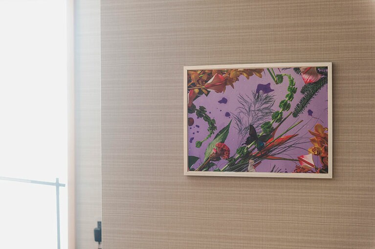 壁に飾られたパープルベースのトロピカルな絵画。