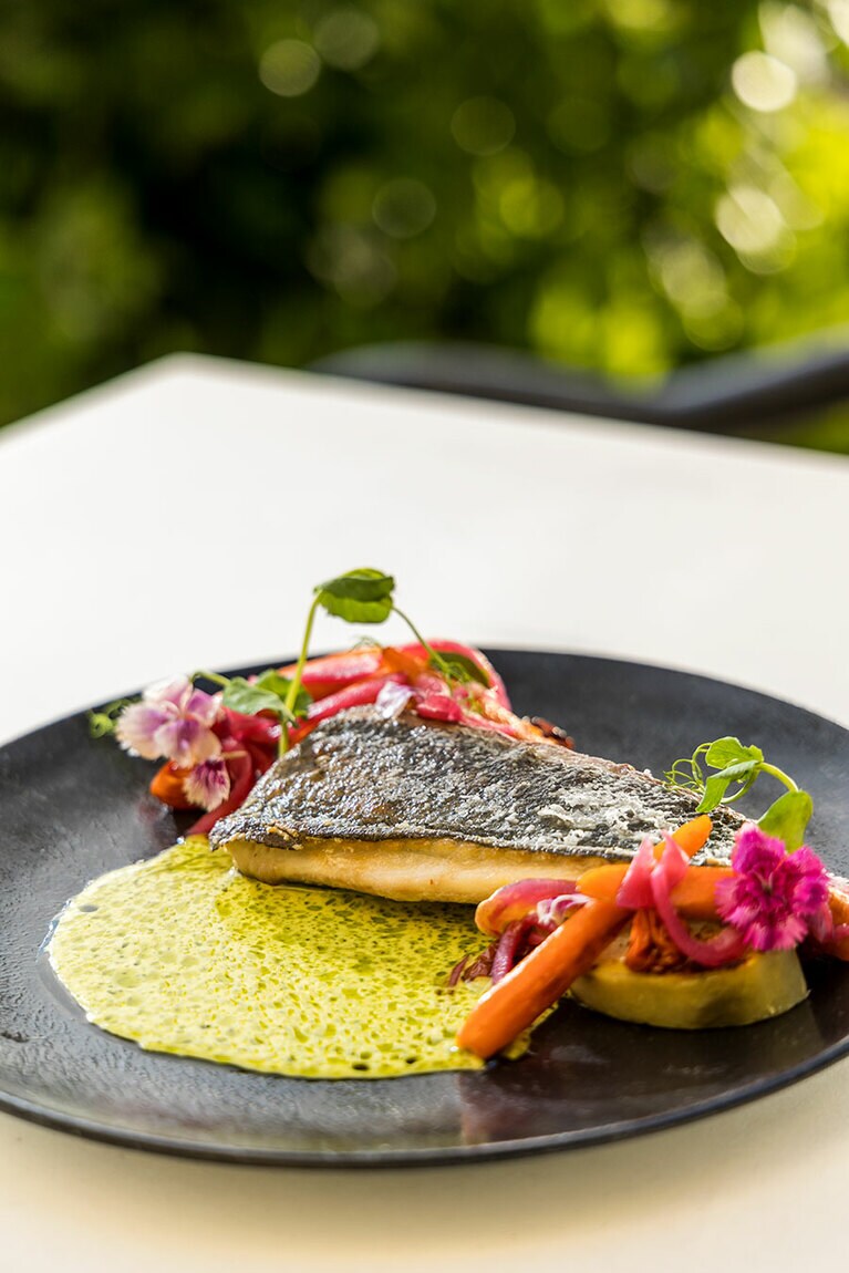 人気の一皿、ココナツカレーソースとの相性がたまらない“コナ産カンパチの炙り焼き” 36ドル。