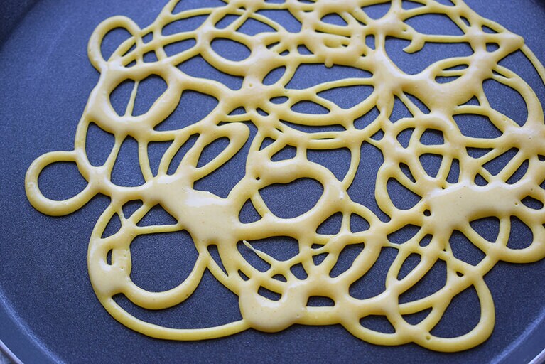 生地を押し出しながら円をいくつも描いていくと、自然にあみ状になる。できるだけ均等の力で容器を押すと、線の細さが一定で美しい。