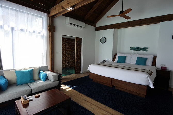 青の差し色が効いているリビング＆スイート。室内に滞在中に使えるバッグとビーチサンダルが用意されています。