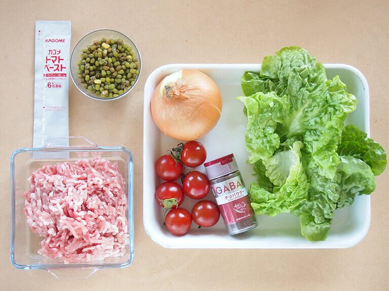 材料（4人前）茹でた緑豆：100g／豚ひき肉：150g／玉ねぎ：1個／ミニトマト：6個／トマトペースト：大さじ1／グリーンリーフ：3枚／チリパウダー：大さじ1／ご飯：人数分／サラダ油：少量／塩：適量／醤油：小さじ1。