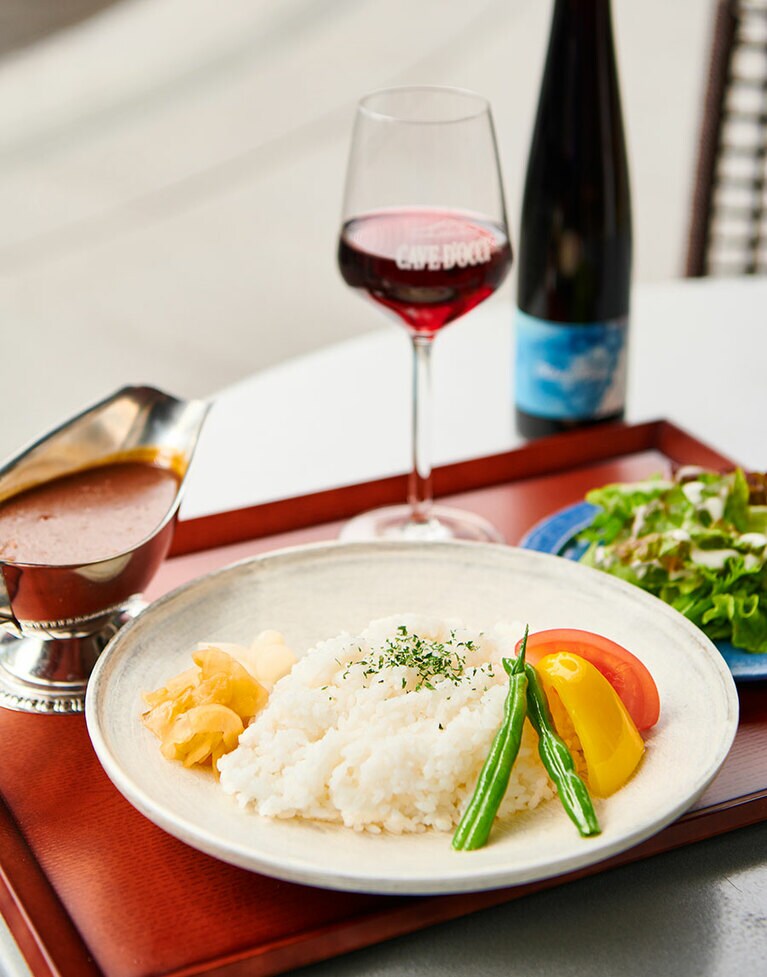 「迎賓館カレー」は赤ワインを使った深く濃い欧風カレー。サラダ付きで1,320円。カーブドッチワイナリーの「迎賓館ワイン」と。