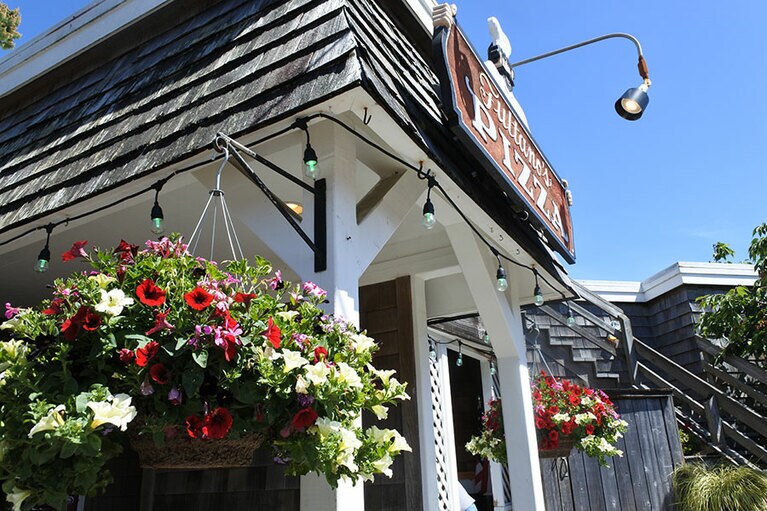 軒先に吊るした花が彩りを添える“シングルズ”という板張りの建物。