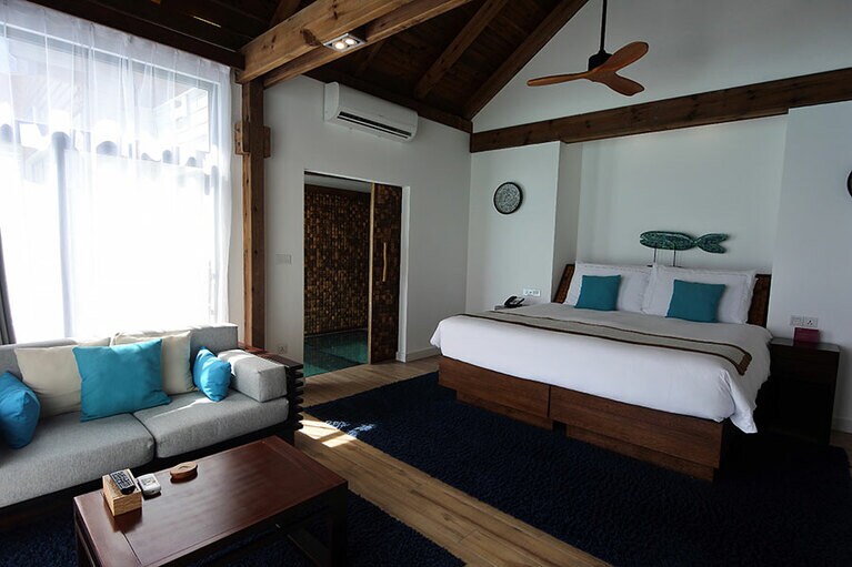 青の差し色が効いているリビング＆スイート。室内に滞在中に使えるバッグとビーチサンダルが用意されています。