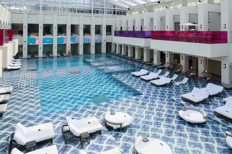 鮮やかなタイルの上に並ぶデイベッド。天井はガラス張りで、開放感たっぷり。