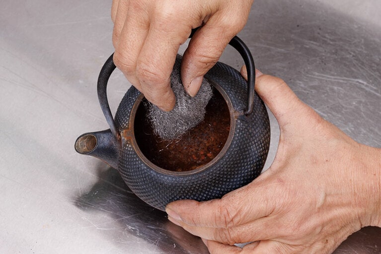 サビを金属タワシ（写真はスチールウールタワシ）でこすってはがす。