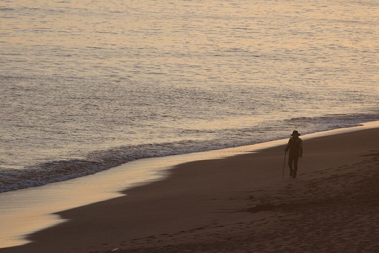 夕暮れの中文ビーチを散歩する老人。夏は華やかなビーチも冬に向かうこの季節はノスタルジックな風情。