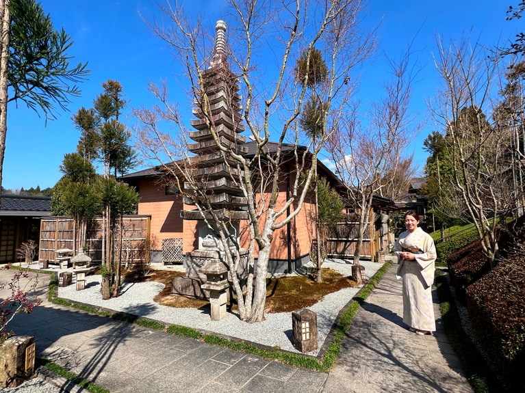 離れの客室へは小径を通って行く。和服の仲居さんがゲストをおもてなししている。