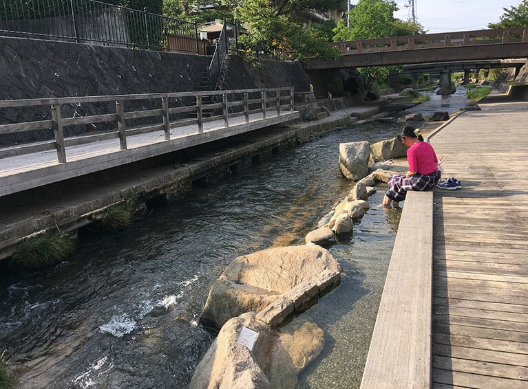 せせらぎを前に足湯に浸かる。玉造温泉の成分には肌にハリとうるおいを与える硫酸イオンが多く含まれているので、湯上りはお肌しっとり。
