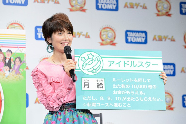 写真は「人生ゲーム」50周年事業発表会にて。同ゲームと同い年である縁からゲストに招かれたのだとか。ボードに書かれた「月給」という生々しい文言と、荻野目ちゃんの爽やかな笑顔とのギャップに悶絶。