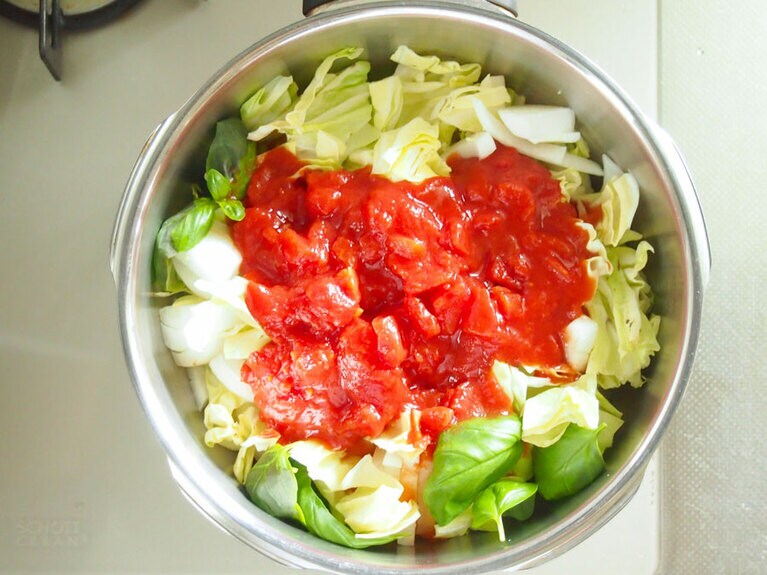 (4) 圧力鍋に(1)のキャベツ、玉ねぎ、生姜、半量のバジル、トマト缶を入れます。バジルの残りの半量は、飾り用にとっておきます。※圧力鍋がない場合は、蓋付きの深鍋を使用しましょう。