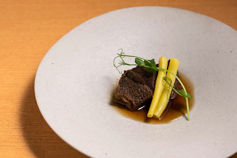 丁寧に煮込んだ和牛と、コクのある出汁がたまらない“しまね和牛ほほ肉の煮込み”。盛り付けたのは、雲州平田の陶芸家・岩佐昌昭さんの白い皿。