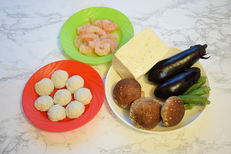 今回、餡に使用したのは、やわらかいグチのつみれ(赤い皿)。味付きなので調味料要らず。具は他に、厚揚げ、苦瓜(中の空洞部分に餡を詰める)もおすすめ。