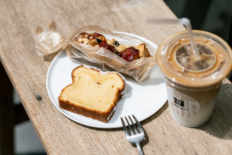 店の前のベンチで。クランブルタルトの手前は国産レモンの果汁を使った「レモンパウンド」テイクアウト 340円、イートイン 347円。カフェラテ（アイス）テイクアウト 540円、イートイン 600円。ベンチでの飲食もイートイン。