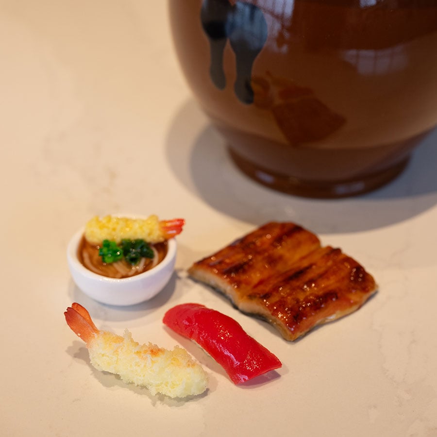 現在でもお馴染みのそば、天ぷら、うなぎ、寿司の4つからテーマを決めるくじ。食品サンプルのくじは見た目にもかわいらしい。くじ引きの結果、今回のテーマはうなぎに決定。今や高級日本料理の代表格だが最初はB級グルメとして誕生したなど、うなぎについて楽しく学んだ。