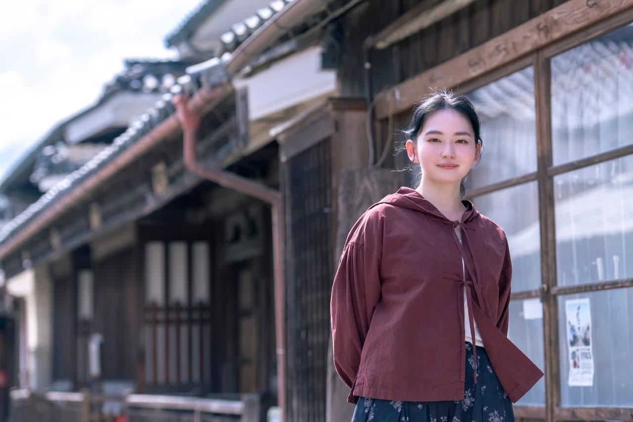 風が通りを抜けると、結んだリボンとスカートの裾がふわりと揺れます。