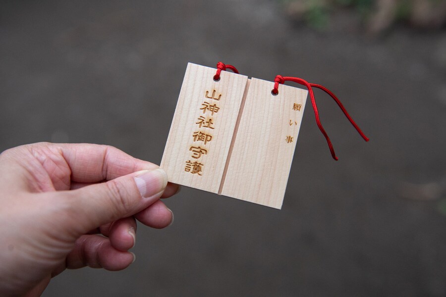 山神社の「割り札」。半分に割り片方に願い事を書き、杉の枝に結び付ける。もう片方はお守りに。
