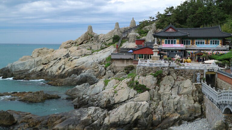 荒々しい岩場を見下ろして立つ海東龍宮寺。