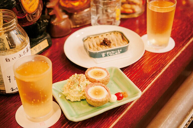 名物のスコッチ・エッグは、ゆで卵をコンビーフで覆い、揚げずに仕上げる。オイルサーディン、ハイボール 各1,000円。