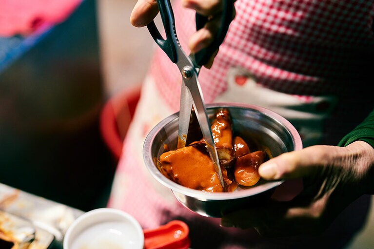 ホテルのそばにある軽食店「チュンム名物キンパ」。オモニがカットしてくれるトッポギ。