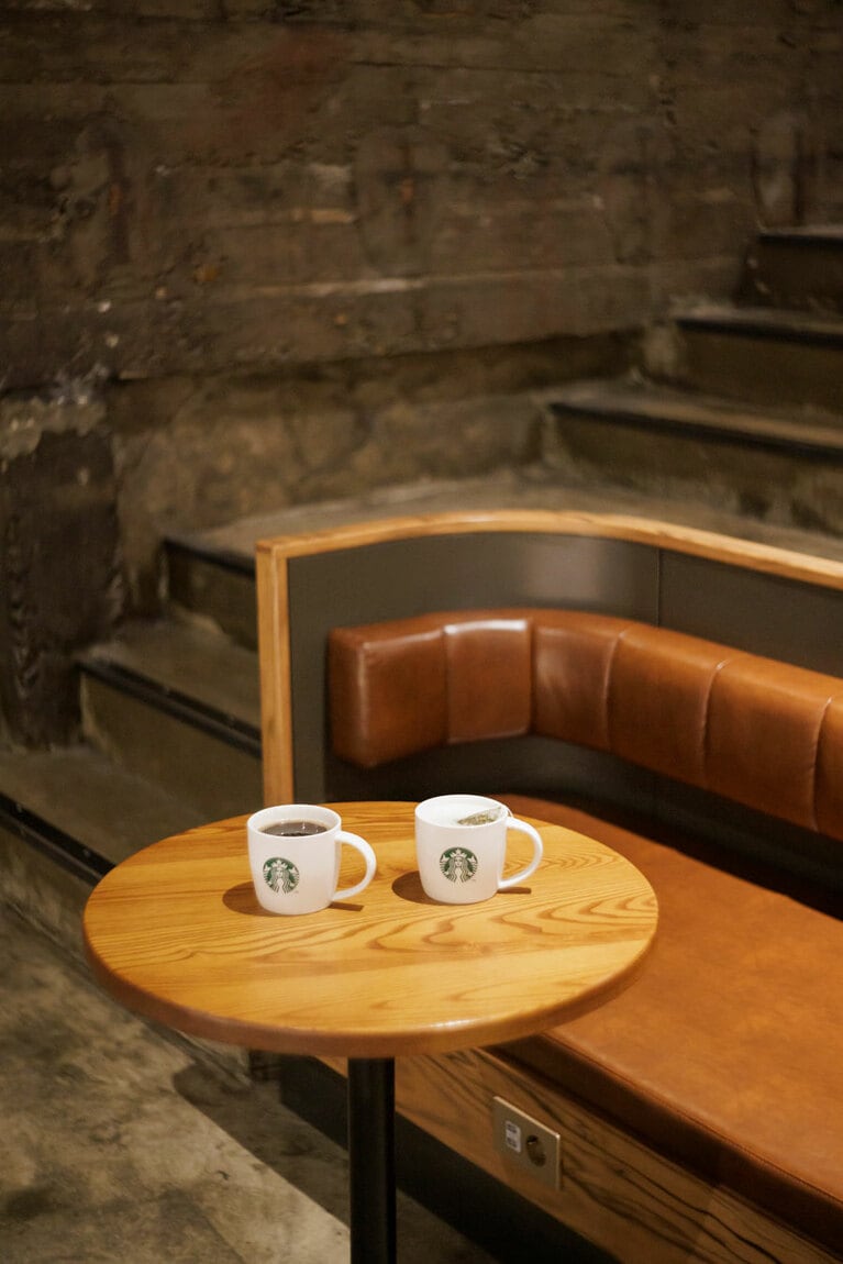 席のスタイルはさまざま。こちらは劇場の傾斜に合わせて作られた1～2人用のブース席。アメリカーノ(トール)W4,500、ゆずミントティー(トール)W5,900。