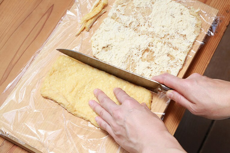 油揚げの端を切り落としているところ。