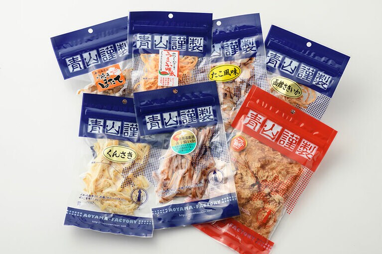 【函館市場】黄金のしいかセット 4,500円。左奥から時計回りに：焼きほたて 60g、明太風味さきいか 40g、たこ風味イカ 70g、函館さきいか 40g、黄金のしいか 1枚、一夜干し焼きイカ 45g、くんさき 70g／マルイチ青山水産　※道外発送価格