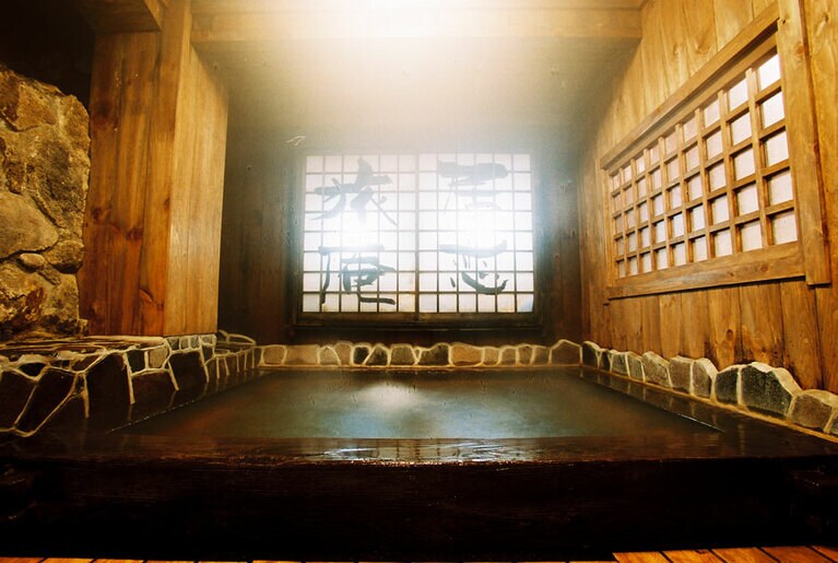 本館と同じ障子がある混浴の箱湯。湯船の底に敷かれた小石が足裏を気持ちよく刺激。