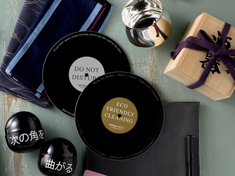 左上から時計回りに、きものテーラー「Y.&SONS」のきもの端切れを使ったスタッフ用チーフ〈A〉、レストランでは、江戸時代にまでさかのぼる名匠の技を継承する日伸貴金属の「東京銀器」酒器が〈U〉、音にこだわるホテルならではのレコード型ドアサイン〈A〉、このたび新しく始まったサービスのカプセルトイ〈A〉。