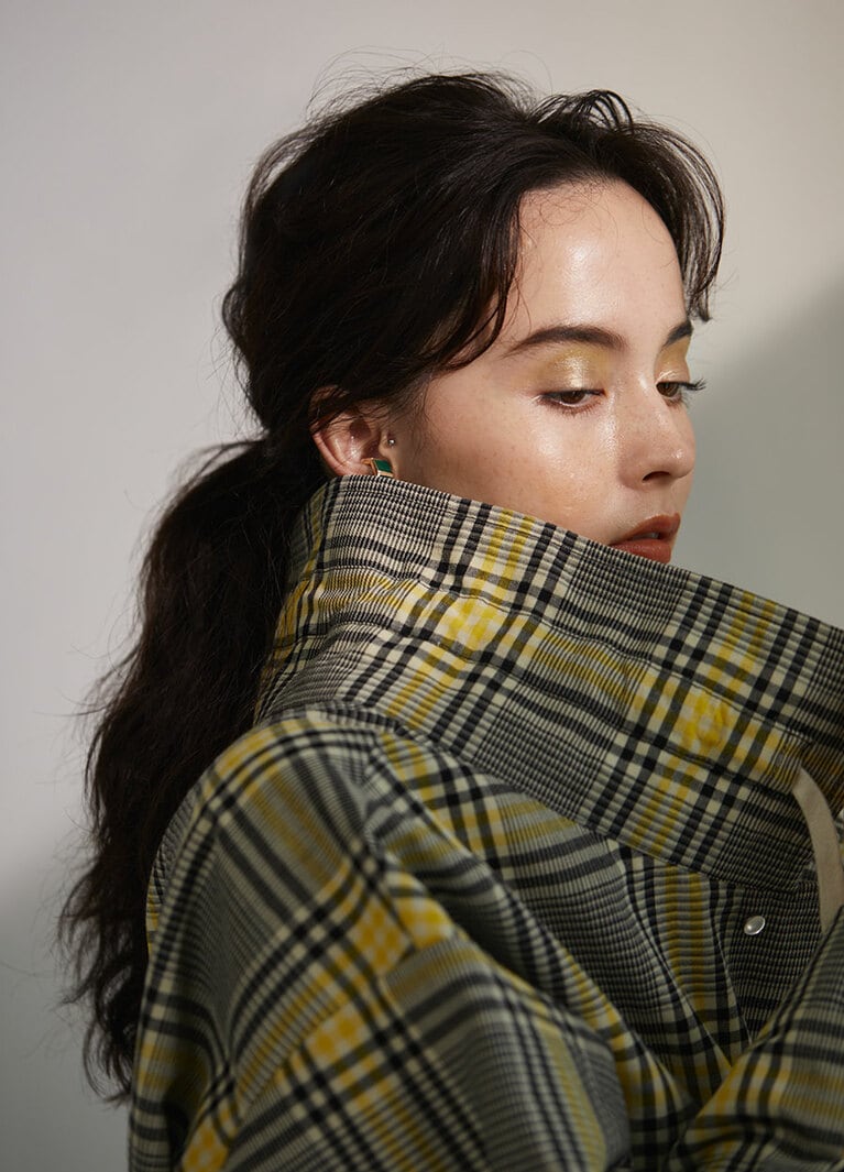 コート 108,000円／ニアー ニッポン(ニアー)、イヤカフとしてつけたタイルリング 55,000円／ララガン(ララガンデザイン)