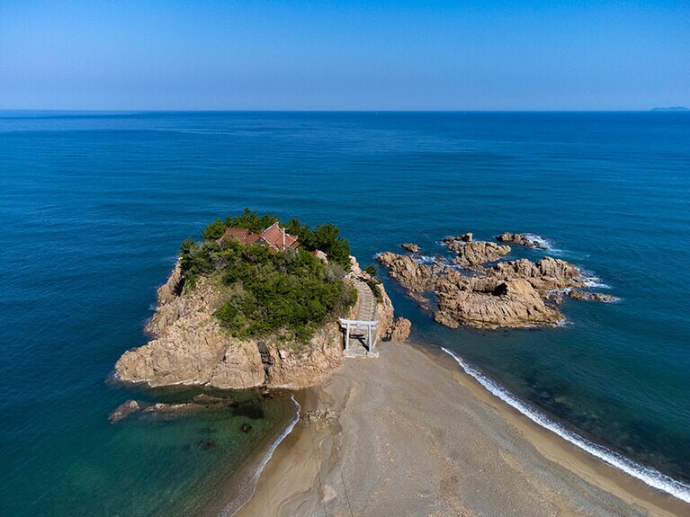 青い海に囲まれた絶景開運スポット、宮ヶ島 衣毘須神社。大潮の満潮時には、神社へ続く浜の参道は海に沈んでしまうそう。
