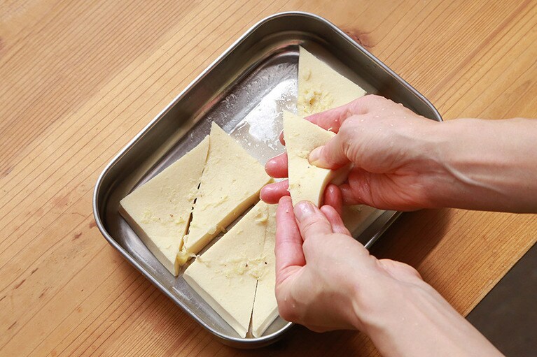 高野豆腐に【A】の下味が染み込むようにギュギュッと握るようにする。まんべんなく味が馴染むように何度か同じ作業を繰り返す。