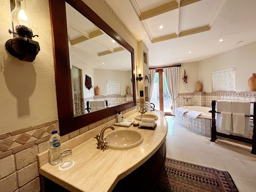 バスルームには、大きな鏡とダブルシンク、シャワーブース、トイレがあり、プールからもウッドデッキを通って、直接入ることができる。