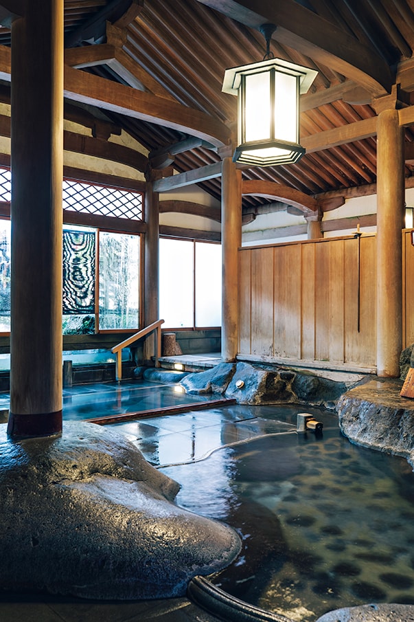 【新井旅館】源泉かけ流しの大浴場「天平大浴堂」は、台湾から運んだ檜を使った総檜造り・天平様式。3代目当主と親しかった安田靫彦画伯が自ら設計し、昭和9年に完成した。灯火は文化勲章受章者・香取秀真氏の作品。Photo: Masahiro Shimazaki