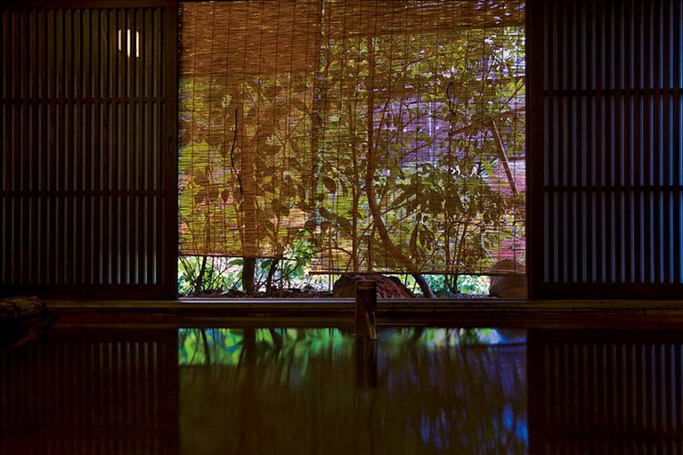 【黒川温泉 いこい旅館】檜の大きな丸太を組んだ女性専用内湯・檜風呂。田の原川沿いにあり、川の流れる音が迫力満点に響く。