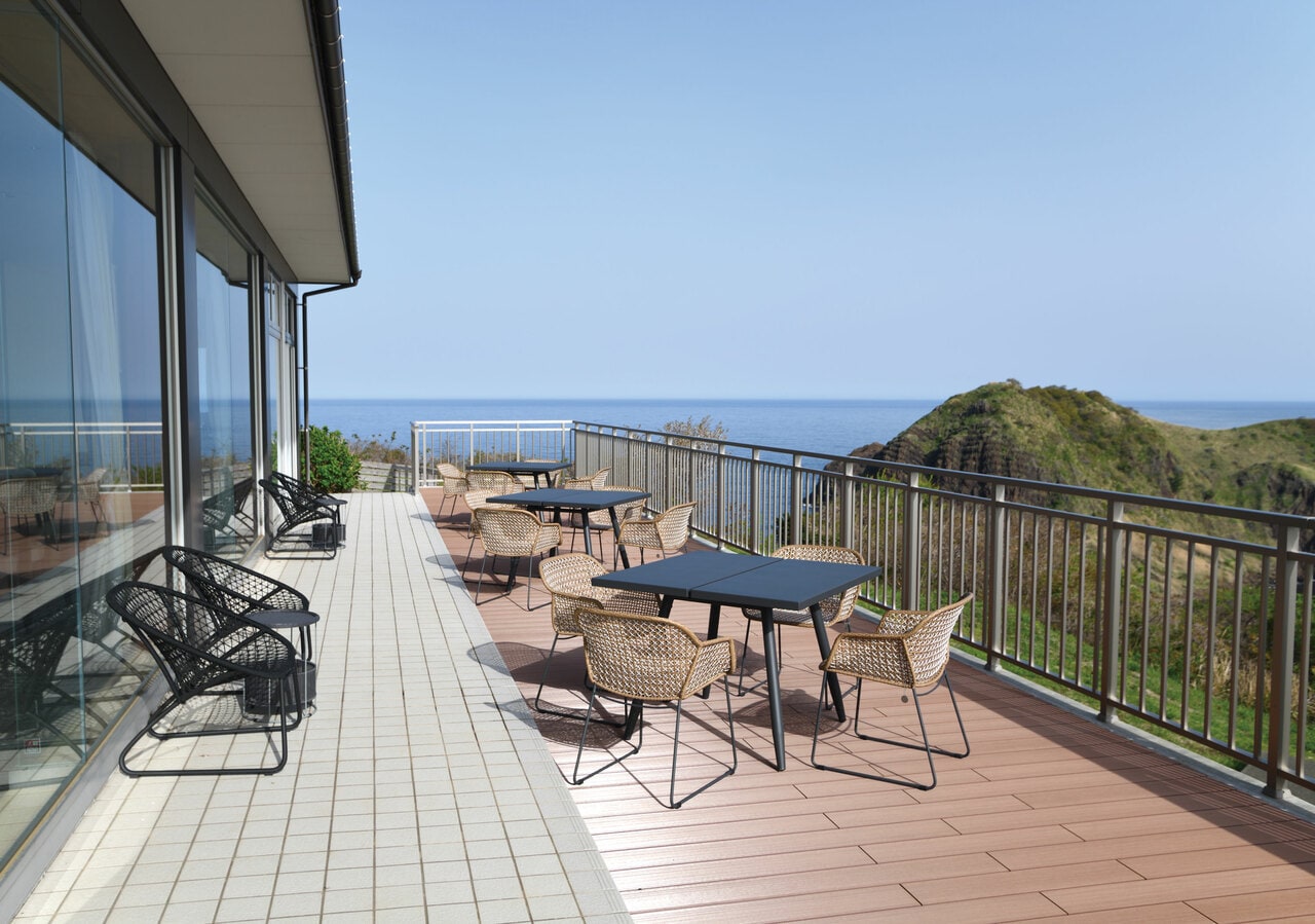 「二ツ亀」と美しい日本海が見渡せる開放感いっぱいのウッドデッキテラス。©SADO二ツ亀ビューホテル